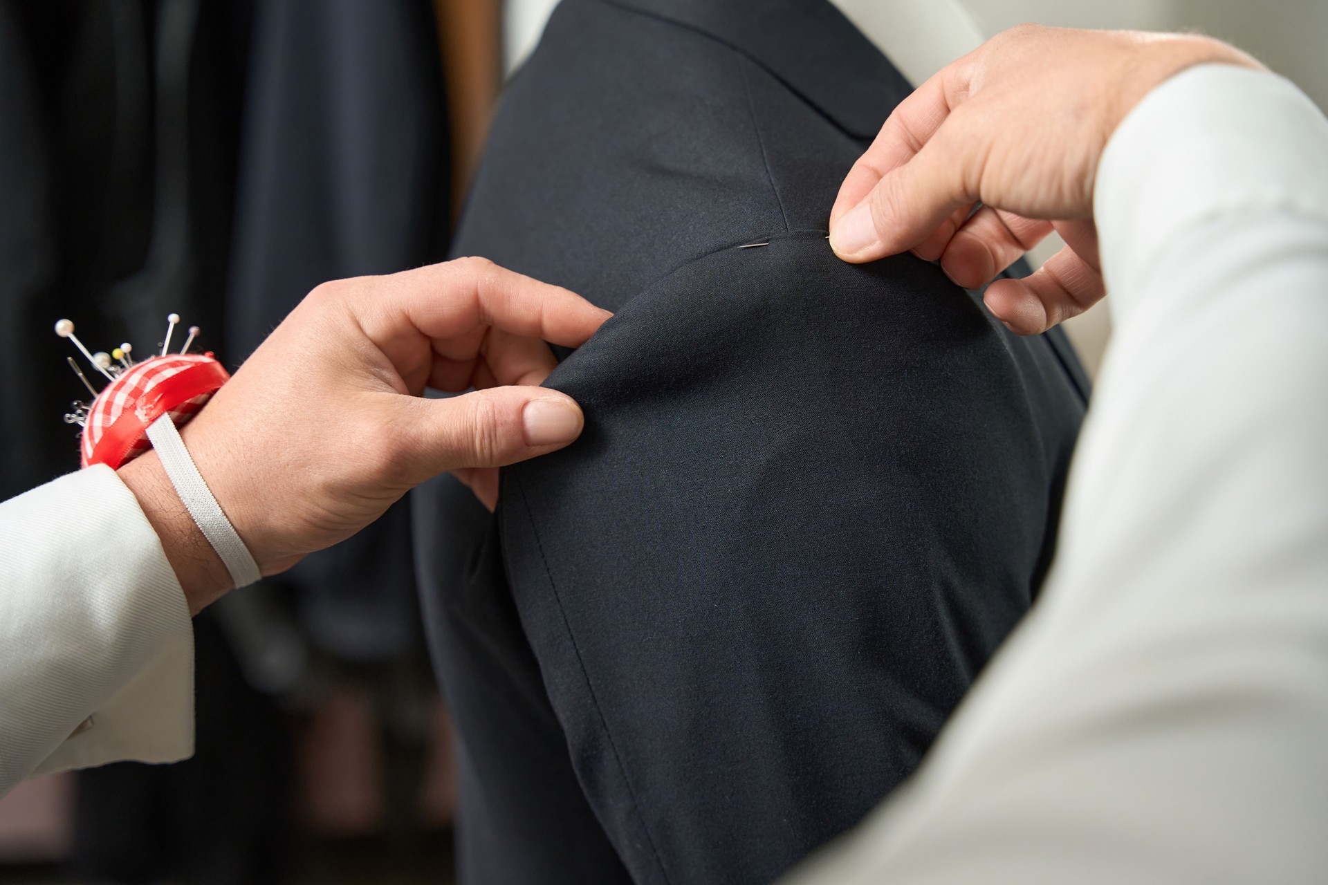 Professional clothier altering item of clothing for client